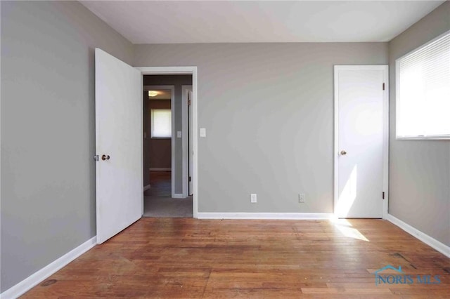 601 Edith Ave, Findlay, OH 45840 - unfurnished bedroom featuring multiple windows and wood finished floors
