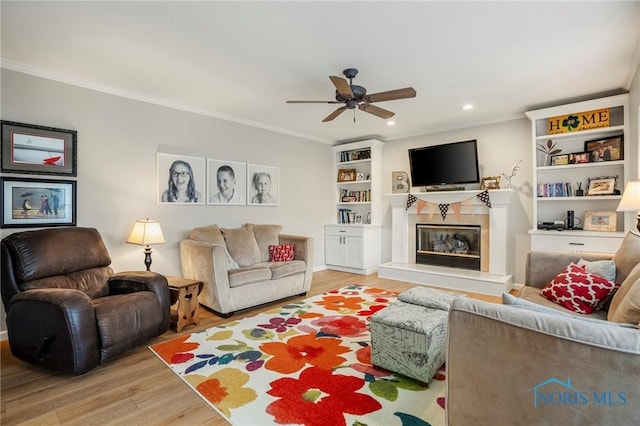 2838 Long View Dr, Maumee, OH 43537 - living room featuring a ceiling fan, light wood-style flooring, a glass covered fireplace, ornamental molding, and recessed lighting