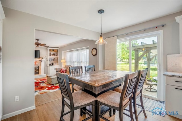 2838 Long View Dr, Maumee, OH 43537 - dining room with a glass covered fireplace, healthy amount of natural light, light wood-style floors, and ceiling fan