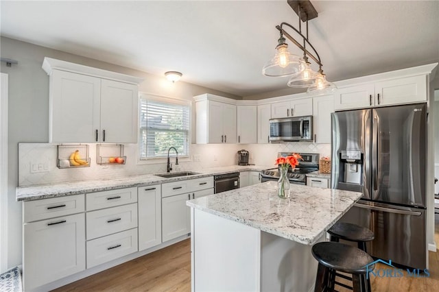 2838 Long View Dr, Maumee, OH 43537 - kitchen featuring stainless steel appliances, white cabinetry, a kitchen breakfast bar, and light wood-style floors