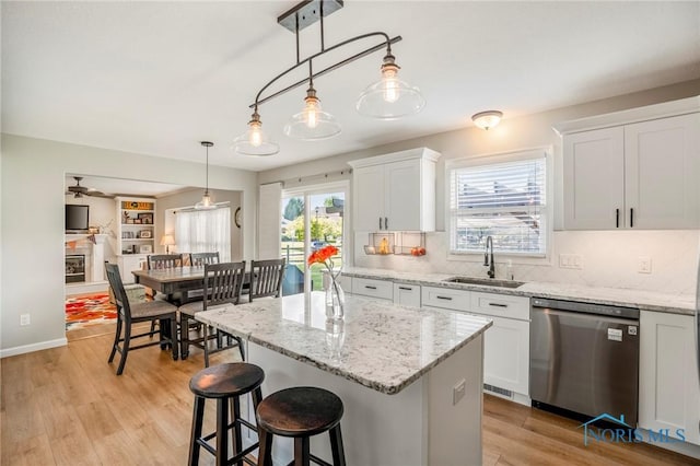 2838 Long View Dr, Maumee, OH 43537 - kitchen featuring stainless steel dishwasher, a center island, white cabinetry, tasteful backsplash, and light wood-style flooring