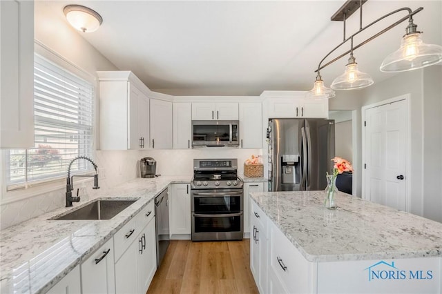 2838 Long View Dr, Maumee, OH 43537 - kitchen featuring stainless steel appliances, a center island, white cabinets, light wood-type flooring, and light stone countertops