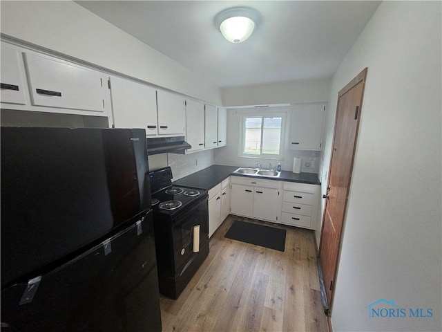 2916 Upton Ave, Toledo, OH 43606 - kitchen featuring black appliances, under cabinet range hood, light wood-type flooring, white cabinets, and dark countertops