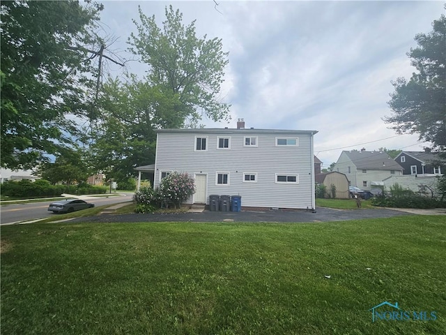 2916 Upton Ave, Toledo, OH 43606 - back of house with a lawn and a chimney