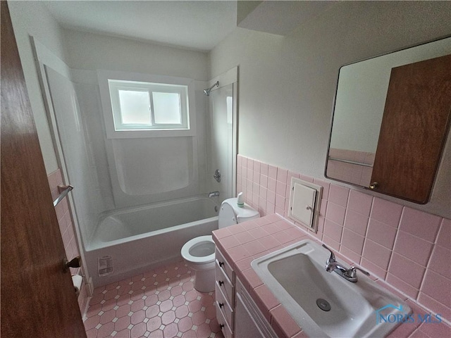 2916 Upton Ave, Toledo, OH 43606 - bathroom featuring tile walls, washtub / shower combination, vanity, tile patterned floors, and wainscoting