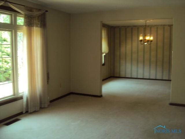 217 Lakeview Dr, Bryan, OH 43506 - spare room with a chandelier and light carpet