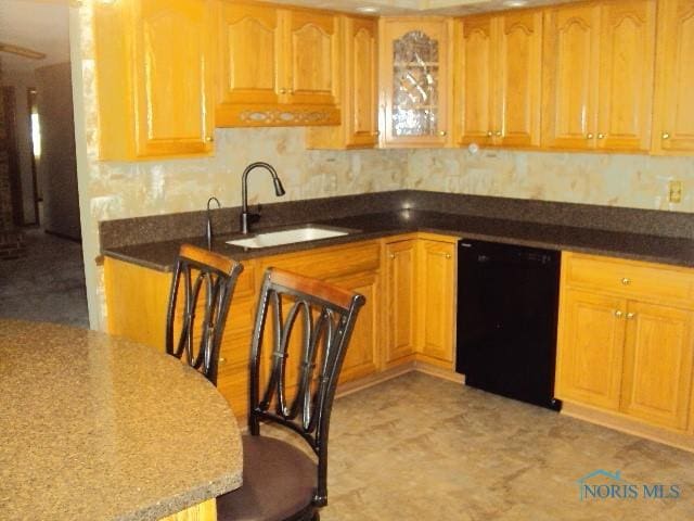 217 Lakeview Dr, Bryan, OH 43506 - kitchen with black dishwasher, dark stone countertops, and glass insert cabinets