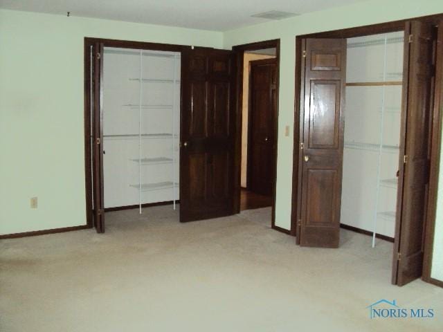 217 Lakeview Dr, Bryan, OH 43506 - unfurnished bedroom with light carpet and two closets