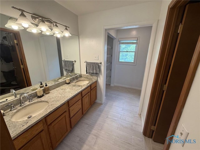 9151 Rolling Hill Rd, Holland, OH 43528 - full bath featuring double vanity, a spacious closet, and wood finished floors