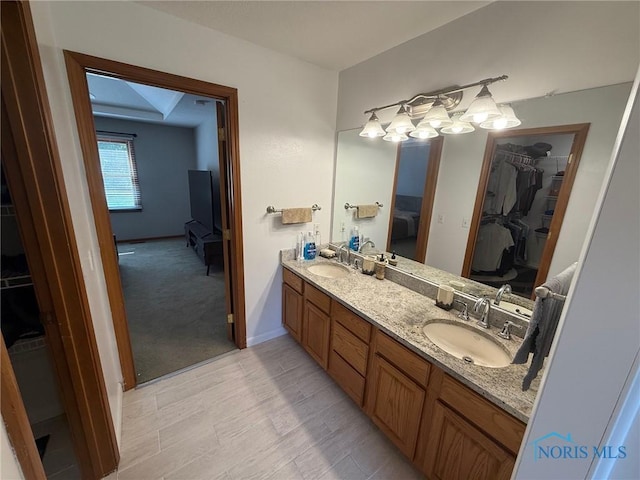 9151 Rolling Hill Rd, Holland, OH 43528 - ensuite bathroom with double vanity, a walk in closet, and wood finished floors