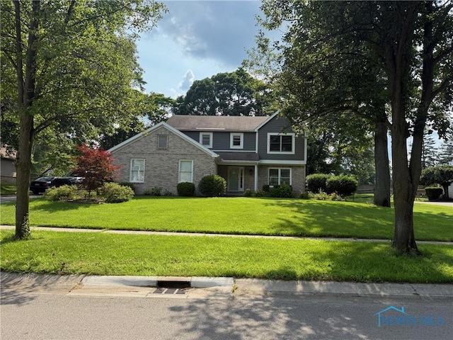 9151 Rolling Hill Rd, Holland, OH 43528 - traditional-style home with a front lawn and brick siding