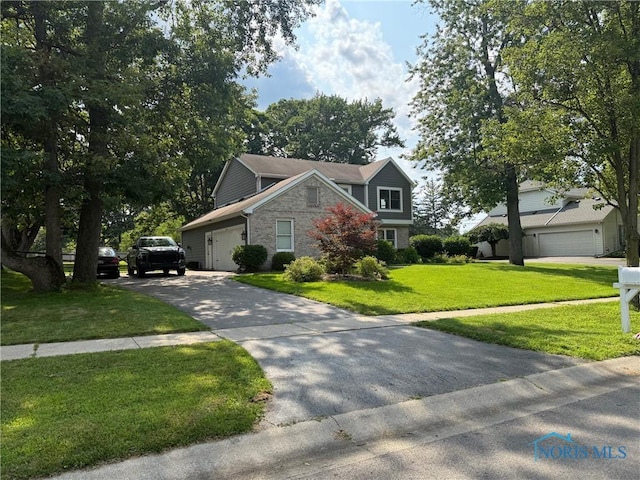 9151 Rolling Hill Rd, Holland, OH 43528 - view of front facade with stone siding, concrete driveway, and a front lawn