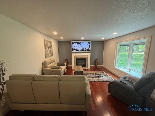 9151 Rolling Hill Rd, Holland, OH 43528 - living area featuring dark wood-type flooring, a fireplace with flush hearth, recessed lighting, and a textured ceiling