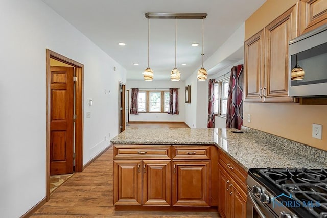 1333 Abbott Ave, Toledo, OH 43614 - kitchen with a peninsula, light wood-type flooring, appliances with stainless steel finishes, light stone countertops, and recessed lighting