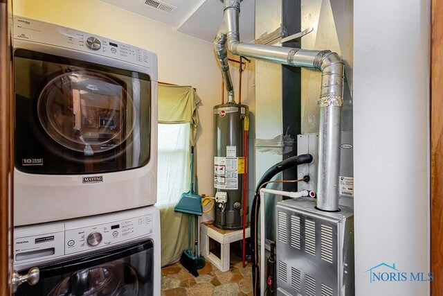 1333 Abbott Ave, Toledo, OH 43614 - laundry room featuring stacked washing machine and dryer, water heater, and stone finish flooring