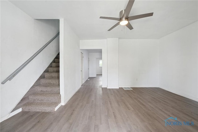 1155 Pinewood Ave, Toledo, OH 43607 - unfurnished room with wood finished floors, stairway, and a ceiling fan