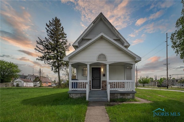 1155 Pinewood Ave, Toledo, OH 43607 - shotgun-style home featuring a porch and a yard
