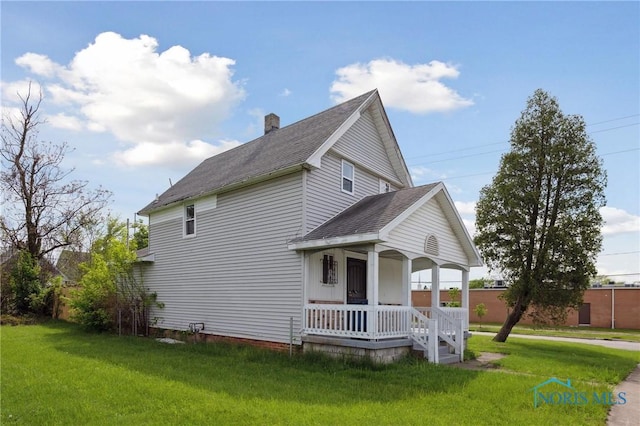 1155 Pinewood Ave, Toledo, OH 43607 - view of front of home with covered porch, roof with shingles, a front yard, and a chimney