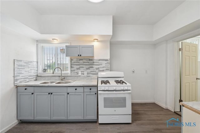 1155 Pinewood Ave, Toledo, OH 43607 - kitchen featuring white gas range, light countertops, backsplash, and dark wood finished floors