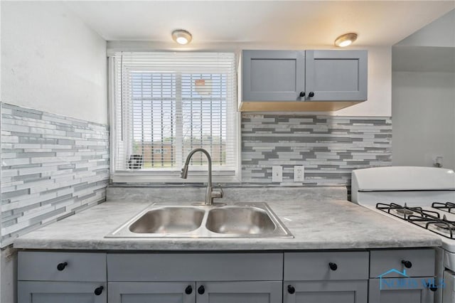1155 Pinewood Ave, Toledo, OH 43607 - kitchen with gas range gas stove, gray cabinetry, tasteful backsplash, and light countertops