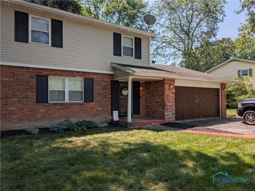 5743 Pinecroft Dr, Toledo, OH 43615 - view of front of property featuring brick siding, a garage, a front lawn, and concrete driveway