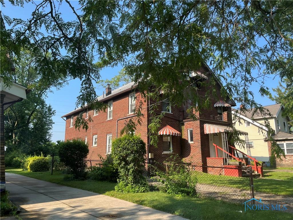 3312 E Manhattan Blvd, Toledo, OH 43611 - view of home's exterior featuring a fenced front yard, brick siding, and a chimney