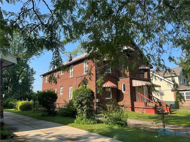 3312 E Manhattan Blvd, Toledo, OH 43611 - view of home's exterior featuring a fenced front yard, brick siding, and a chimney