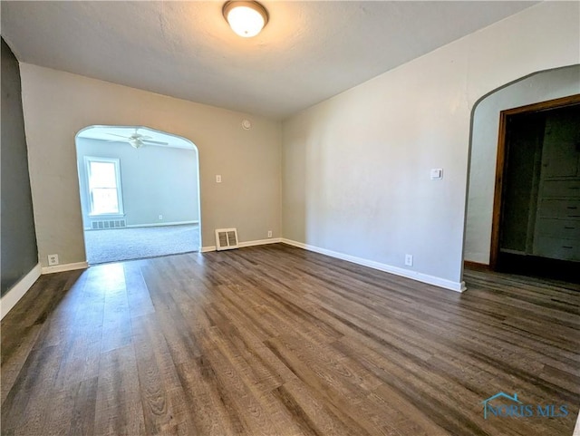 312 S Elm St, Pioneer, OH 43554 - unfurnished room with arched walkways and dark wood-style flooring