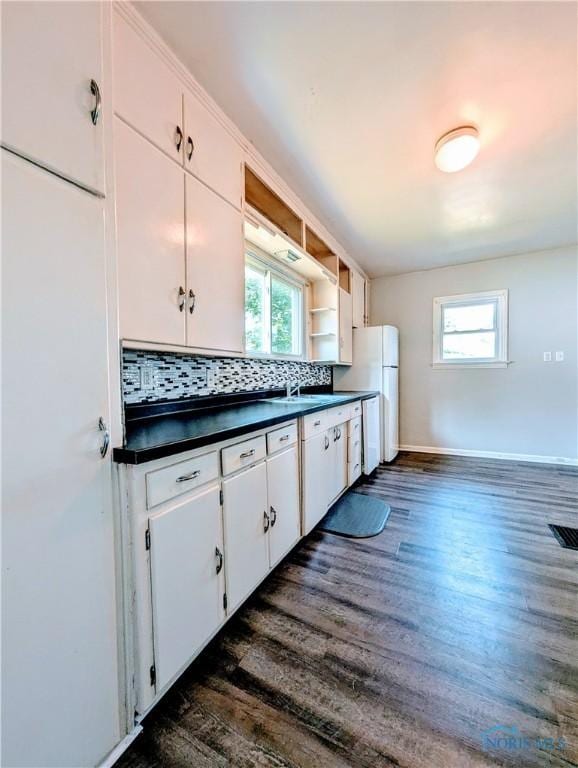 312 S Elm St, Pioneer, OH 43554 - kitchen featuring dark countertops, healthy amount of natural light, white appliances, and dark wood finished floors
