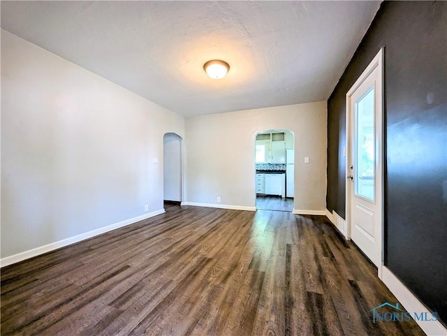312 S Elm St, Pioneer, OH 43554 - unfurnished room with arched walkways and dark wood finished floors