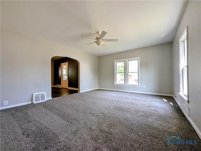 312 S Elm St, Pioneer, OH 43554 - unfurnished room with dark carpet, a ceiling fan, and arched walkways