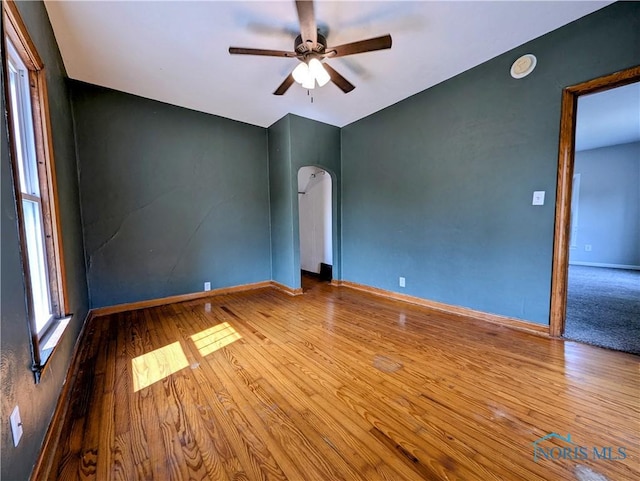 312 S Elm St, Pioneer, OH 43554 - empty room featuring ceiling fan, wood finished floors, and arched walkways