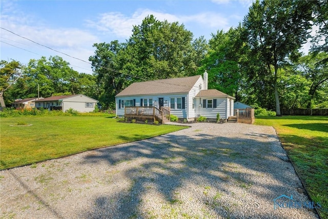 6006 Blossman Rd, Toledo, OH 43617 - view of front of house with gravel driveway, a deck, a chimney, and a front lawn