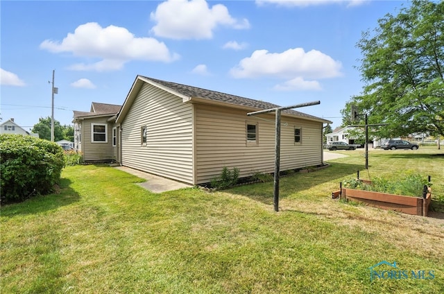 719 S Shannon St, Van Wert, OH 45891 - view of side of property with a vegetable garden, a lawn, and a shingled roof