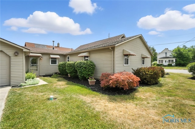 719 S Shannon St, Van Wert, OH 45891 - view of side of property featuring a lawn, a garage, and driveway