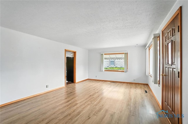 719 S Shannon St, Van Wert, OH 45891 - empty room with light wood-style floors and a textured ceiling
