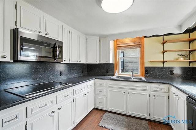 719 S Shannon St, Van Wert, OH 45891 - kitchen with stainless steel microwave, black electric cooktop, white cabinetry, dark wood-type flooring, and decorative backsplash