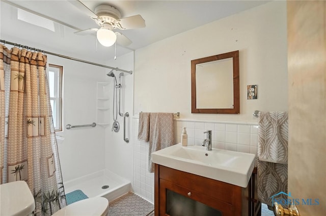 719 S Shannon St, Van Wert, OH 45891 - bathroom with tile walls, a shower with curtain, vanity, ceiling fan, and wainscoting