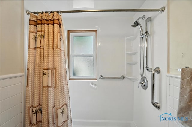 719 S Shannon St, Van Wert, OH 45891 - bathroom with curtained shower, tile walls, and wainscoting