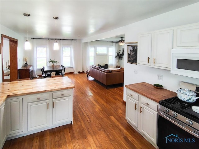 15740 Hill Rd, Defiance, OH 43512 - kitchen with butcher block counters, stainless steel gas range, white microwave, and white cabinetry
