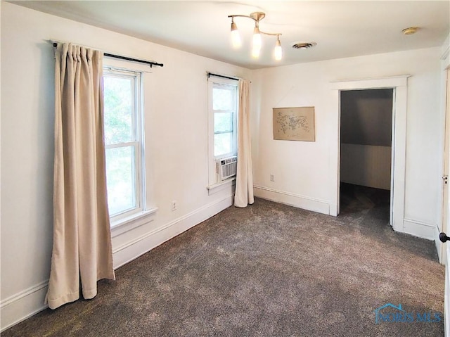 15740 Hill Rd, Defiance, OH 43512 - unfurnished bedroom featuring multiple windows, dark carpet, and cooling unit