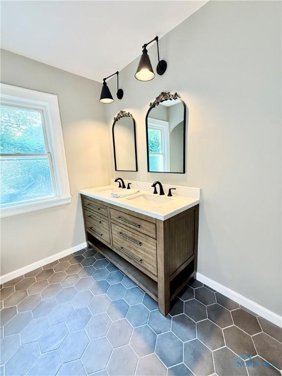 2515 Densmore Dr, Toledo, OH 43606 - full bath featuring double vanity, healthy amount of natural light, and tile patterned floors