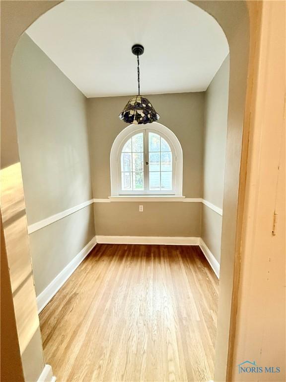 2515 Densmore Dr, Toledo, OH 43606 - unfurnished dining area with arched walkways and wood finished floors