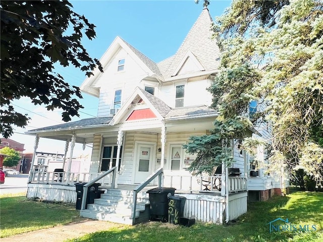 221 S 7th St, Upper Sandusky, OH 43351 - victorian-style house featuring covered porch, roof with shingles, and a front yard