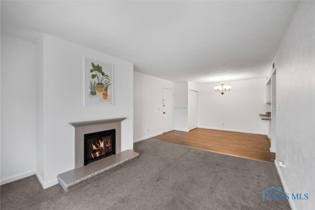 6201 Garden Rd Unit A14, Maumee, OH 43537 - unfurnished living room with carpet floors, a warm lit fireplace, and a chandelier
