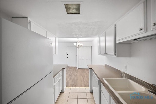 6201 Garden Rd Unit A14, Maumee, OH 43537 - kitchen with white appliances, a chandelier, white cabinetry, light tile patterned flooring, and hanging light fixtures