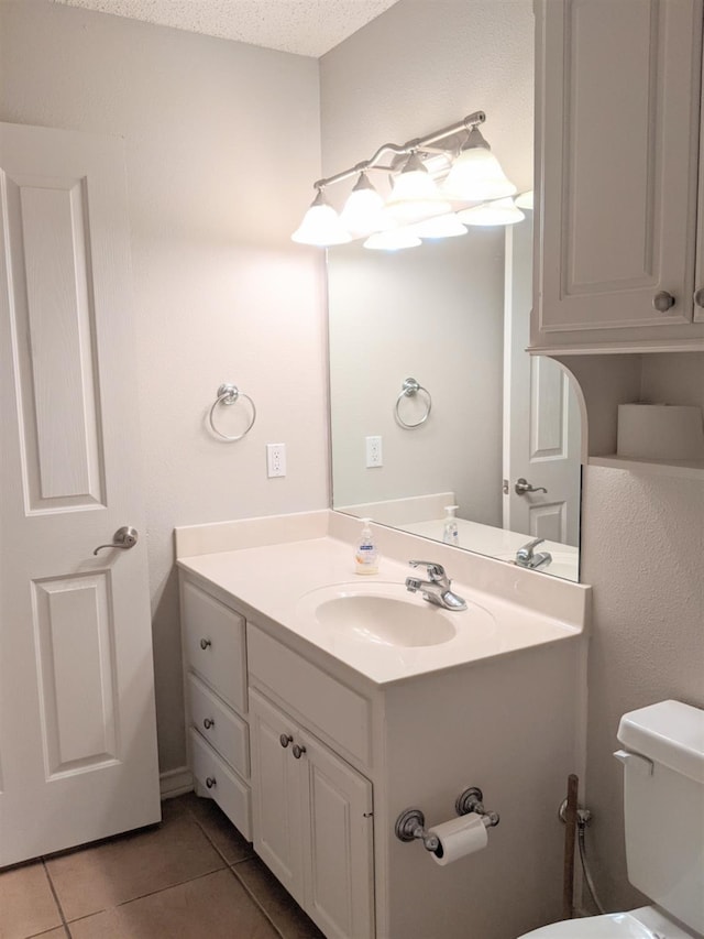 bathroom featuring tile patterned flooring, vanity, a textured ceiling, and toilet