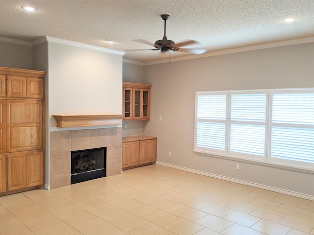 unfurnished living room with a tiled fireplace, crown molding, a textured ceiling, and ceiling fan