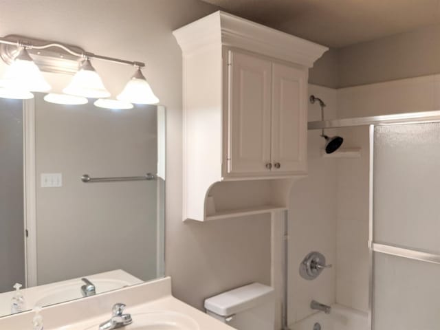 full bathroom with enclosed tub / shower combo, vanity, and toilet