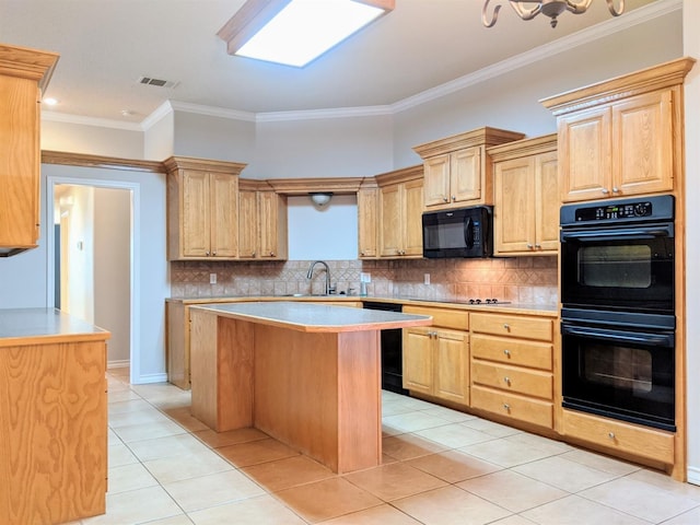 kitchen featuring sink, tasteful backsplash, black appliances, a kitchen island, and light brown cabinets